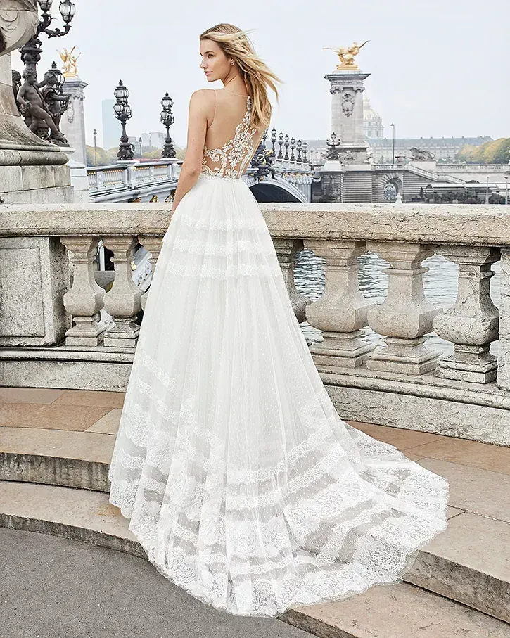 Una mujer con un vestido de novia blanco está parada en un puente.