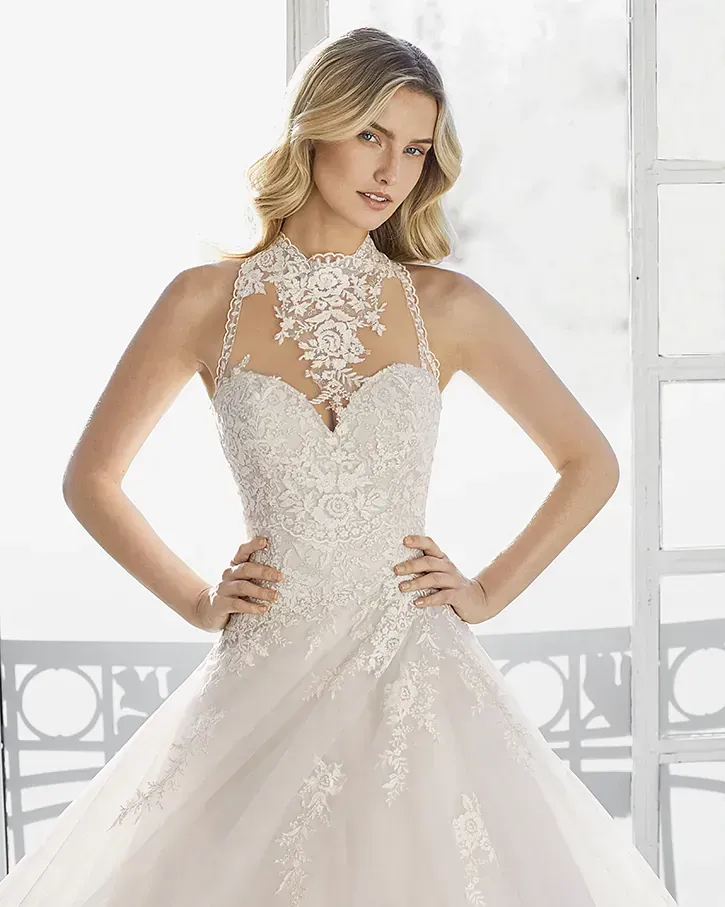 Una mujer lleva un vestido de novia blanco con escote halter.