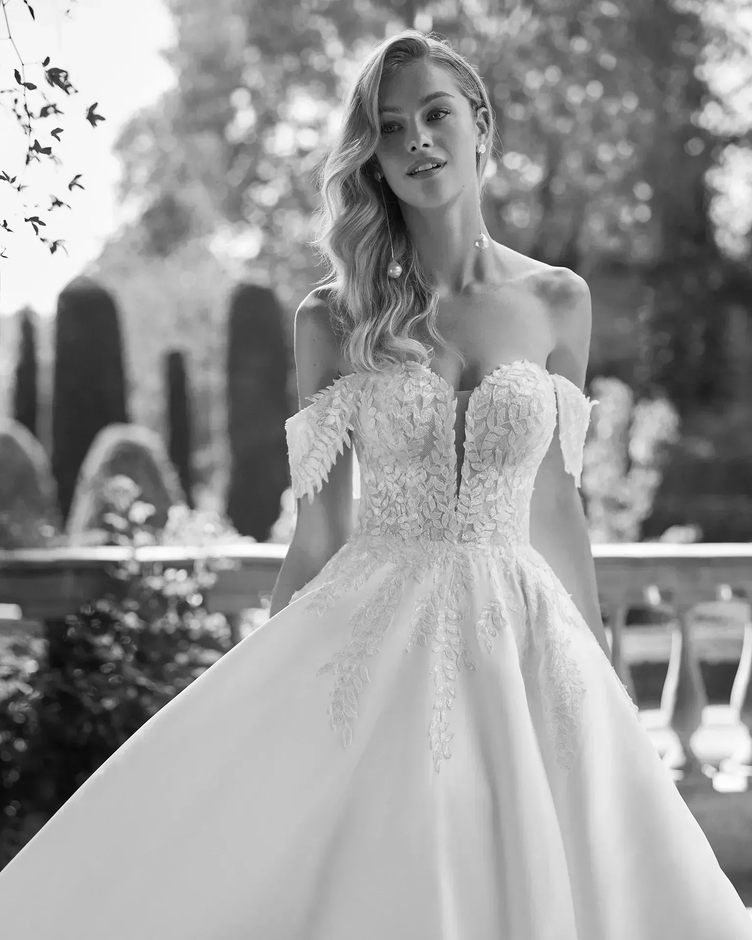 Una mujer con un vestido de novia está parada frente a una fuente.