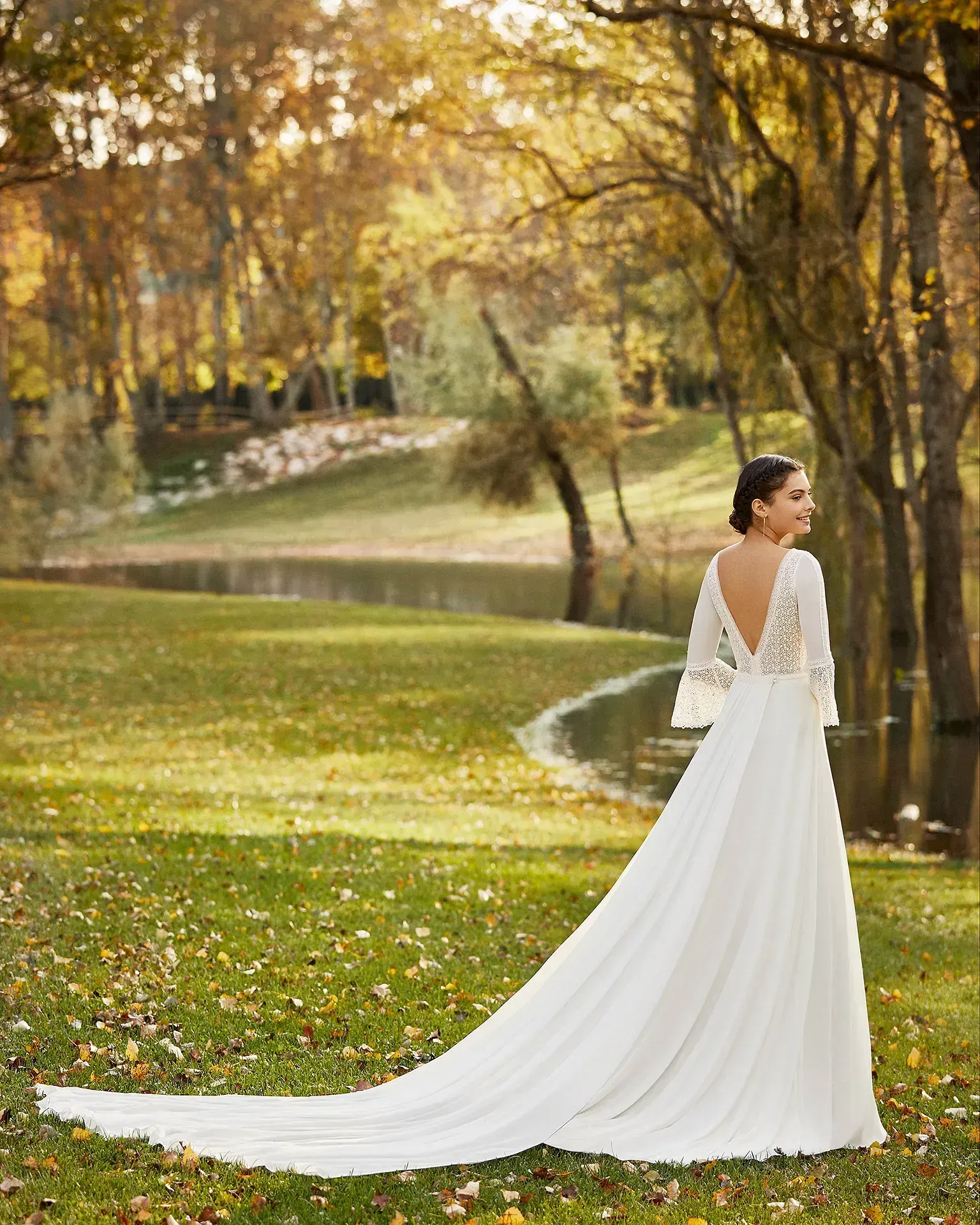 Una mujer con un vestido de novia blanco está parada en un parque.