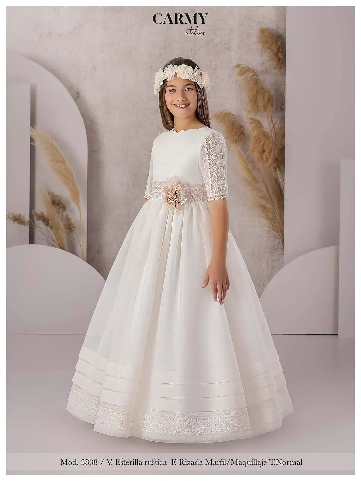 Una niña lleva un vestido blanco y una corona de flores.