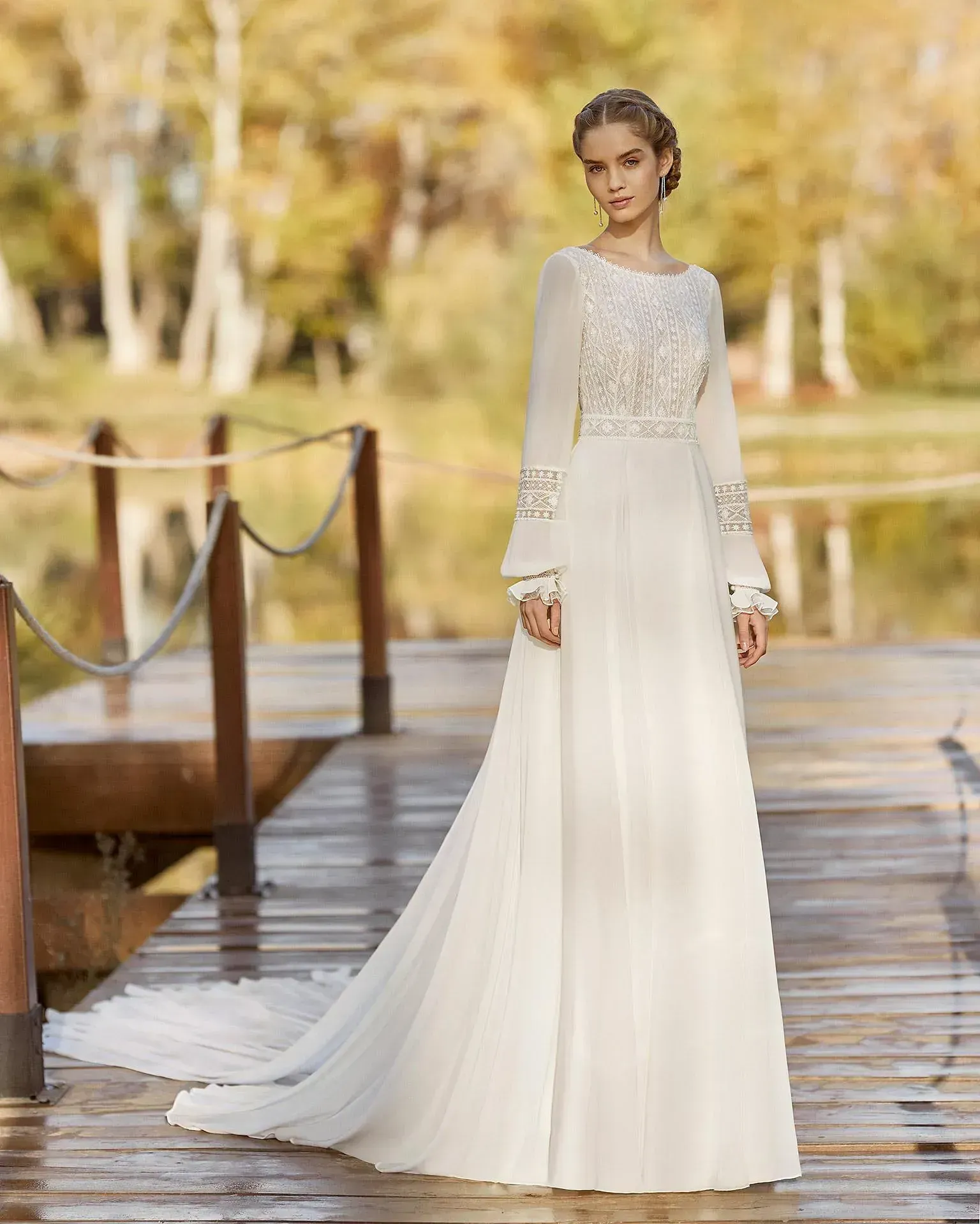 Una mujer con un vestido de novia blanco está parada en un muelle.