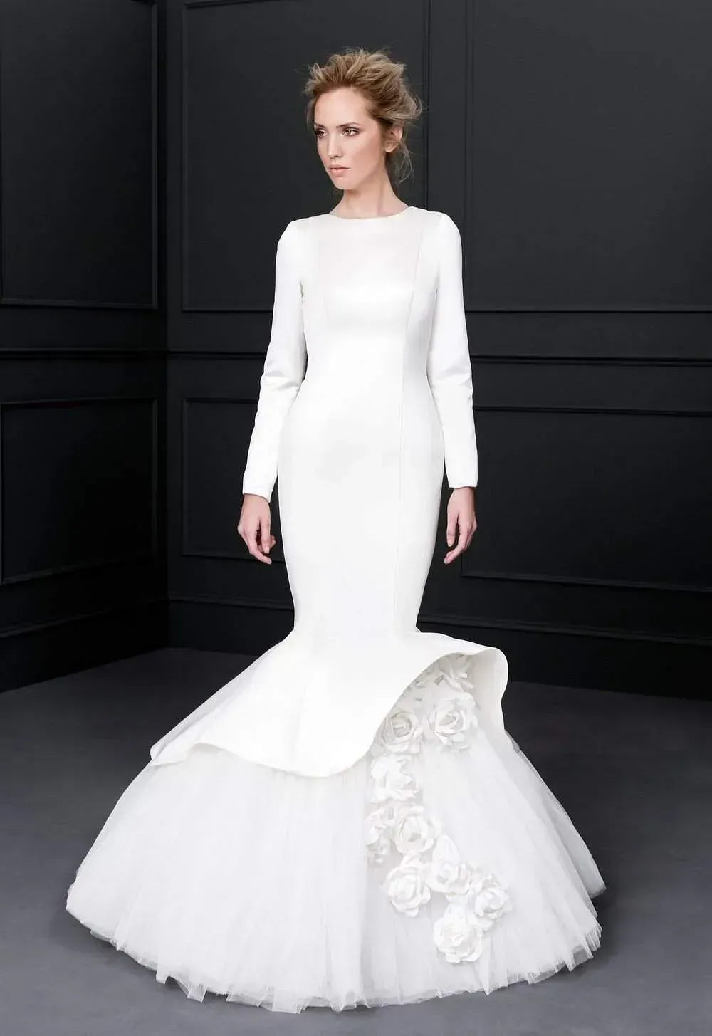 Una mujer con un vestido de novia blanco con mangas largas