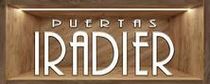 Logotipo de "Iradier Doors" en un nicho de madera, iluminado desde arriba.