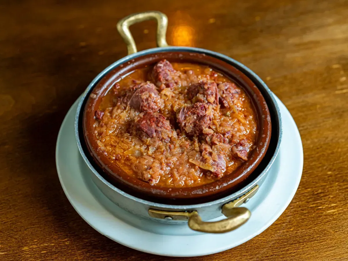 Un plato de comida está en un plato blanco sobre una mesa de madera.