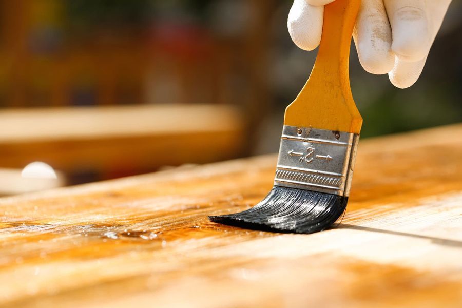 Una persona está usando un rodillo de pintura amarillo para pintar una pared.