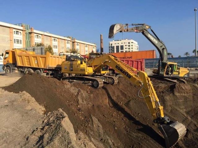 Una excavadora Komatsu está cargando tierra en un camión volquete.