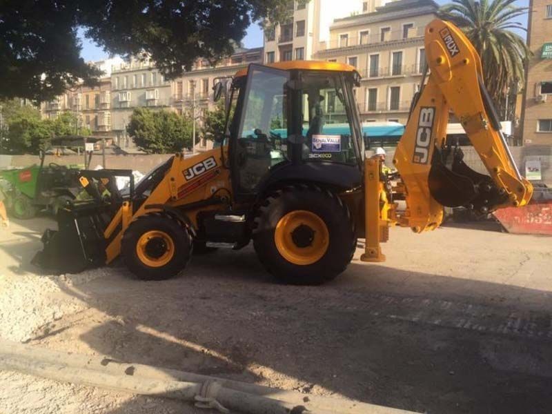 Un tractor JCB amarillo está estacionado en un estacionamiento.