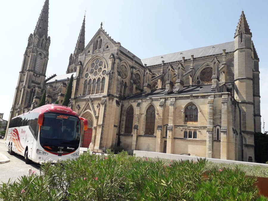 Un autobús está estacionado frente a una gran iglesia.