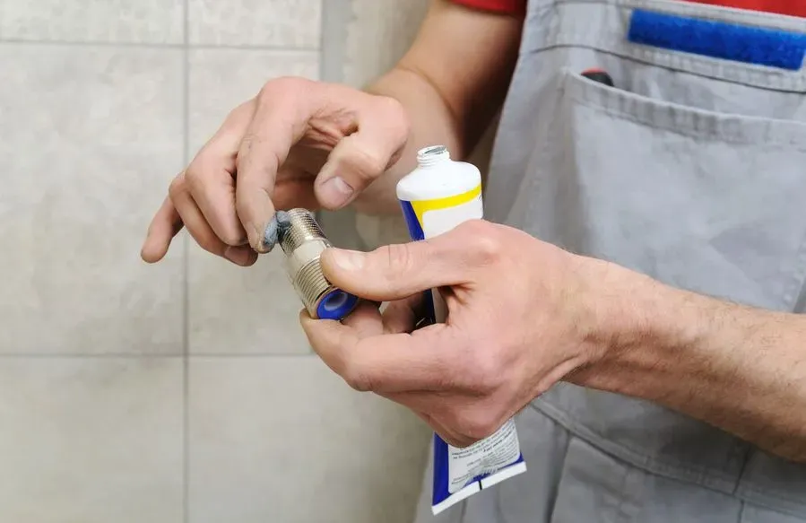 Un hombre sostiene un tubo de pasta de dientes en sus manos.