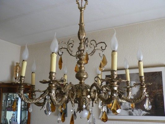 Una lámpara de araña de latón cuelga del techo en una sala de estar.