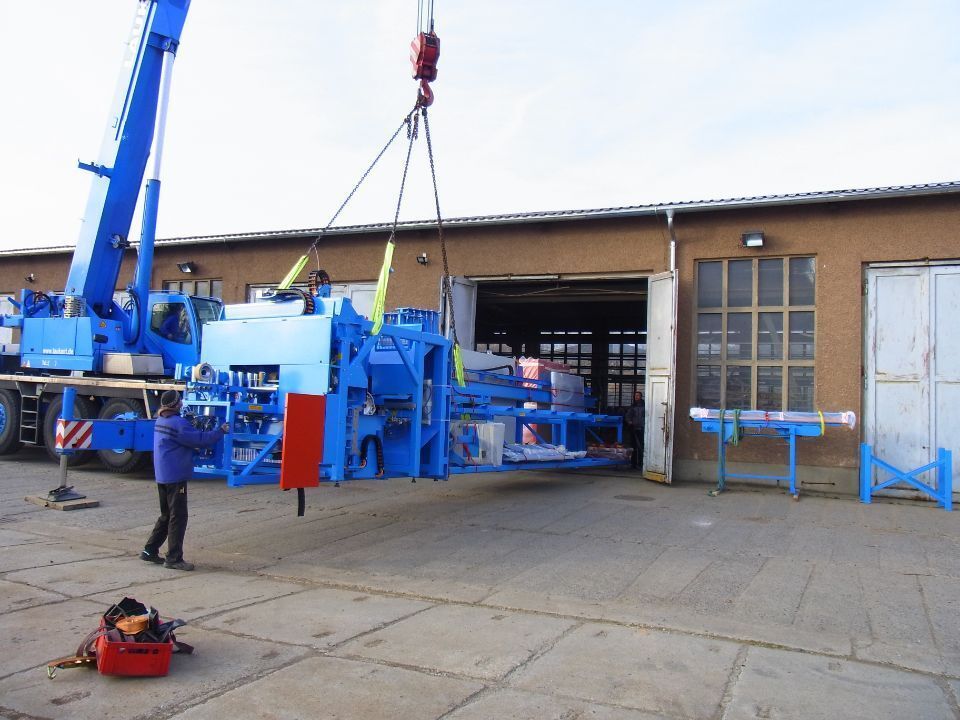 Vier Mitarbeiter vor einer Holzverarbeitungsmaschine