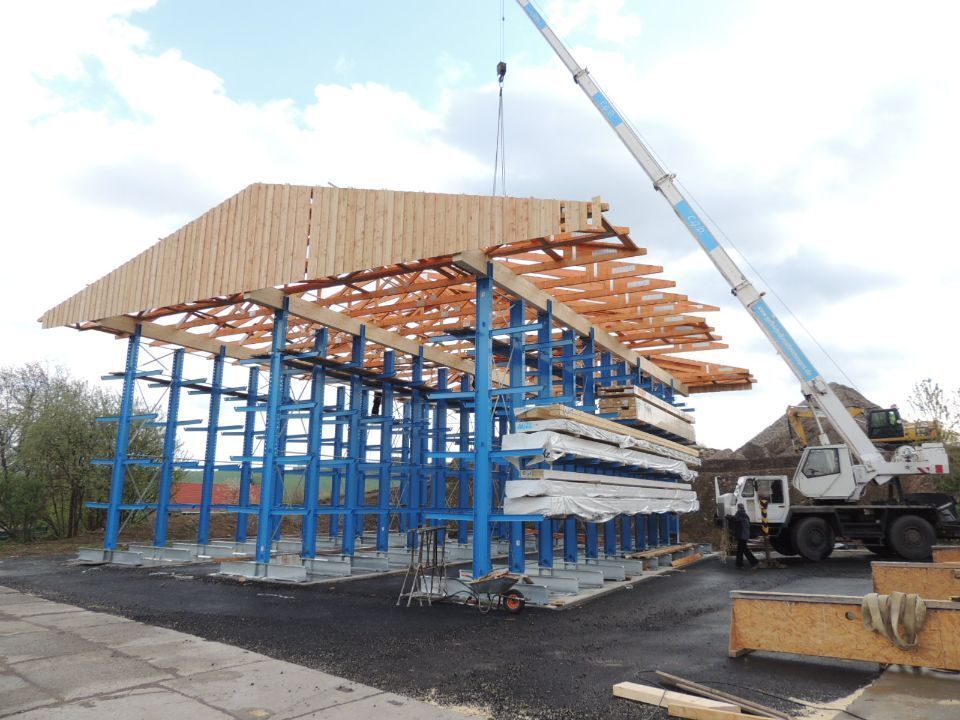 Alt text: Dachstuhl aus Holz wird mit Kran auf den Rohbau gehoben