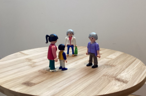 Un grupo de figuras de Playmobil están de pie sobre una mesa de madera.