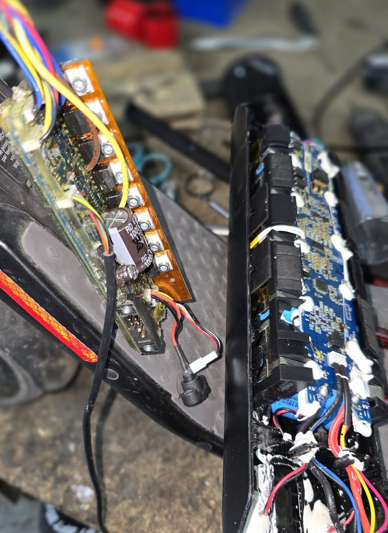 Un primer plano de un dispositivo electrónico roto con cables saliendo de él.