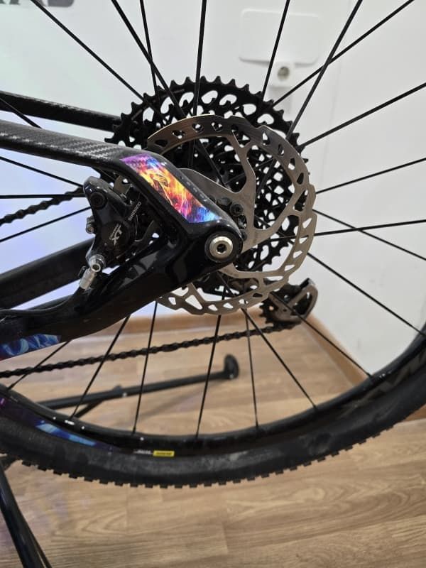 Un primer plano de la rueda trasera de una bicicleta sobre un piso de madera.