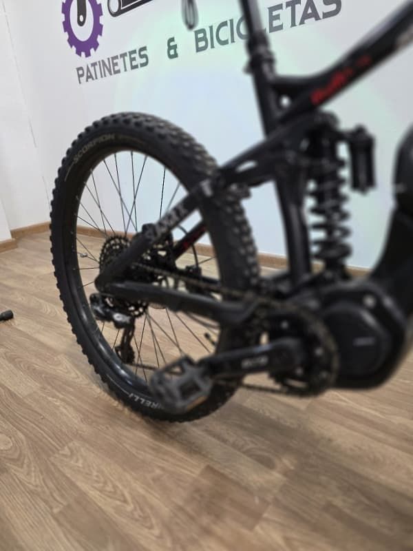 Una bicicleta está estacionada frente a un cartel que dice patinetes y bicicletas