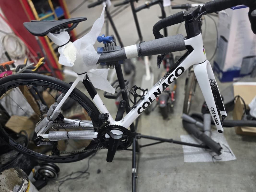 Una bicicleta Colnago está en un soporte en un garaje.