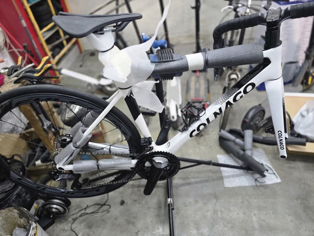 Una bicicleta Colnago está en un soporte en un garaje.