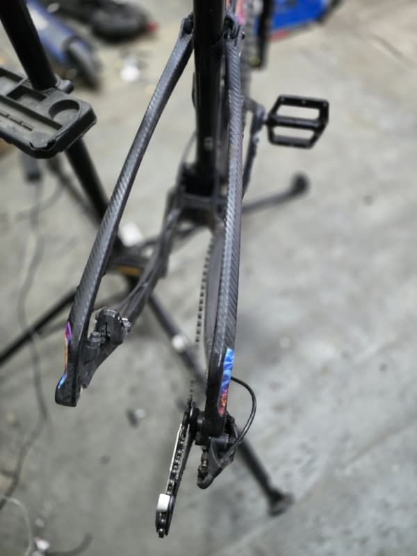 Un cuadro de bicicleta está sobre un soporte en un garaje.