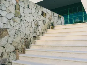 Escalier extérieur avec un mur en pierre.