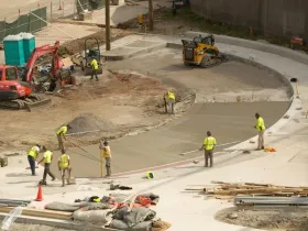 Plusieurs ouvriers réalisant une route avec des engins.