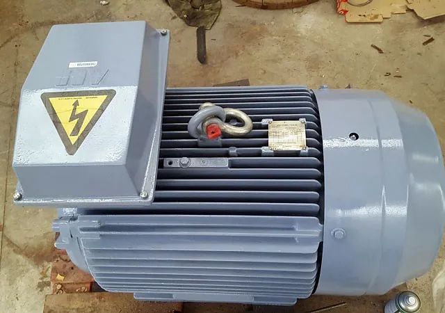 Un gran motor eléctrico está sentado sobre una paleta de madera.