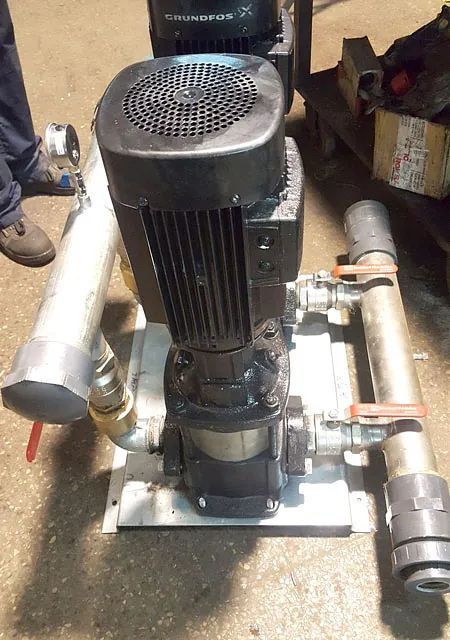 Un motor eléctrico negro está sentado encima de una plataforma de metal.