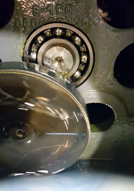 Un primer plano de un rodamiento de bolas sobre una superficie metálica.