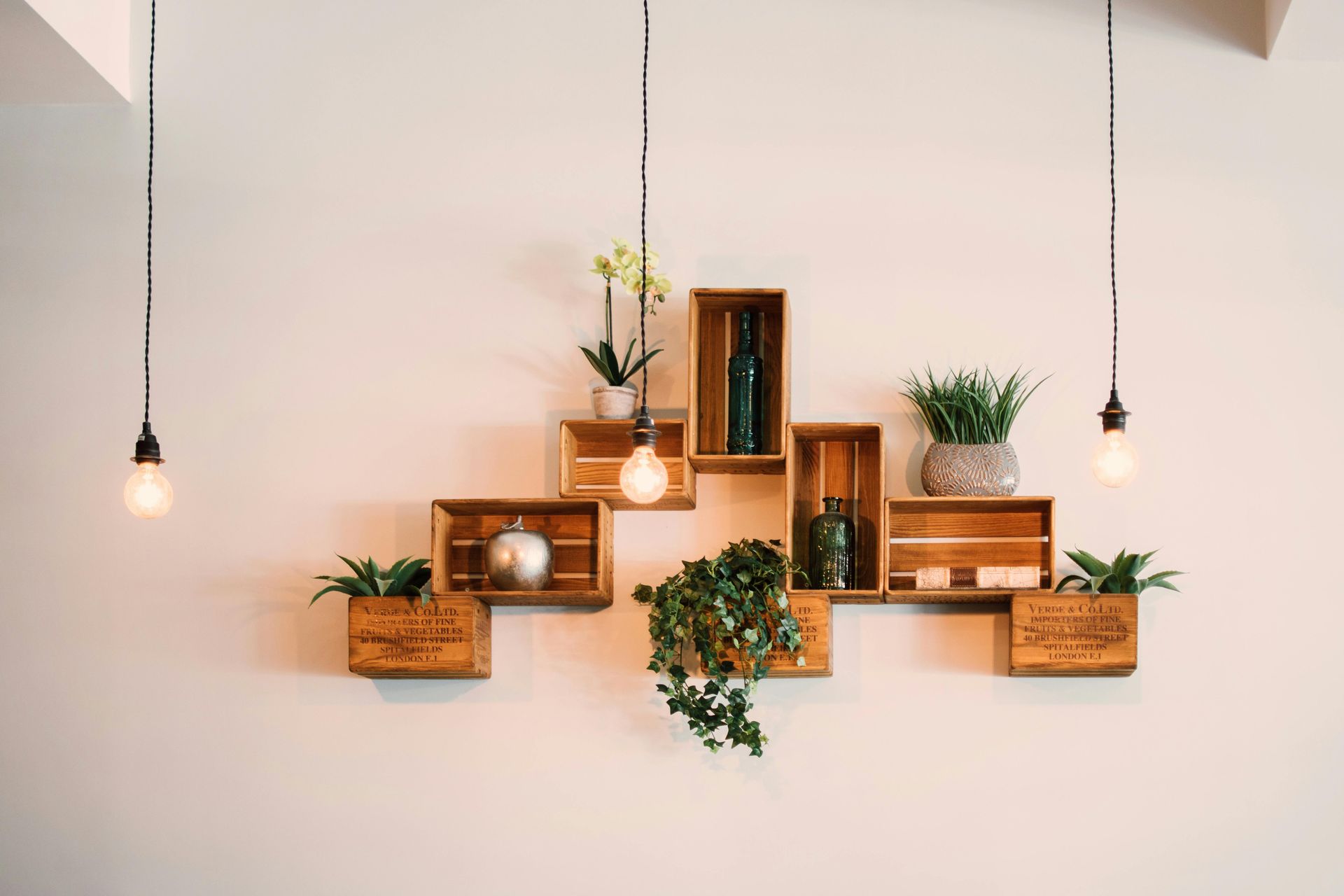 Una pared con un montón de estantes de madera con plantas en macetas en ellos.