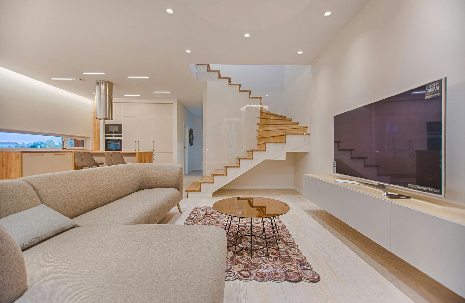 Una sala de estar con sofá, televisión y escaleras.
