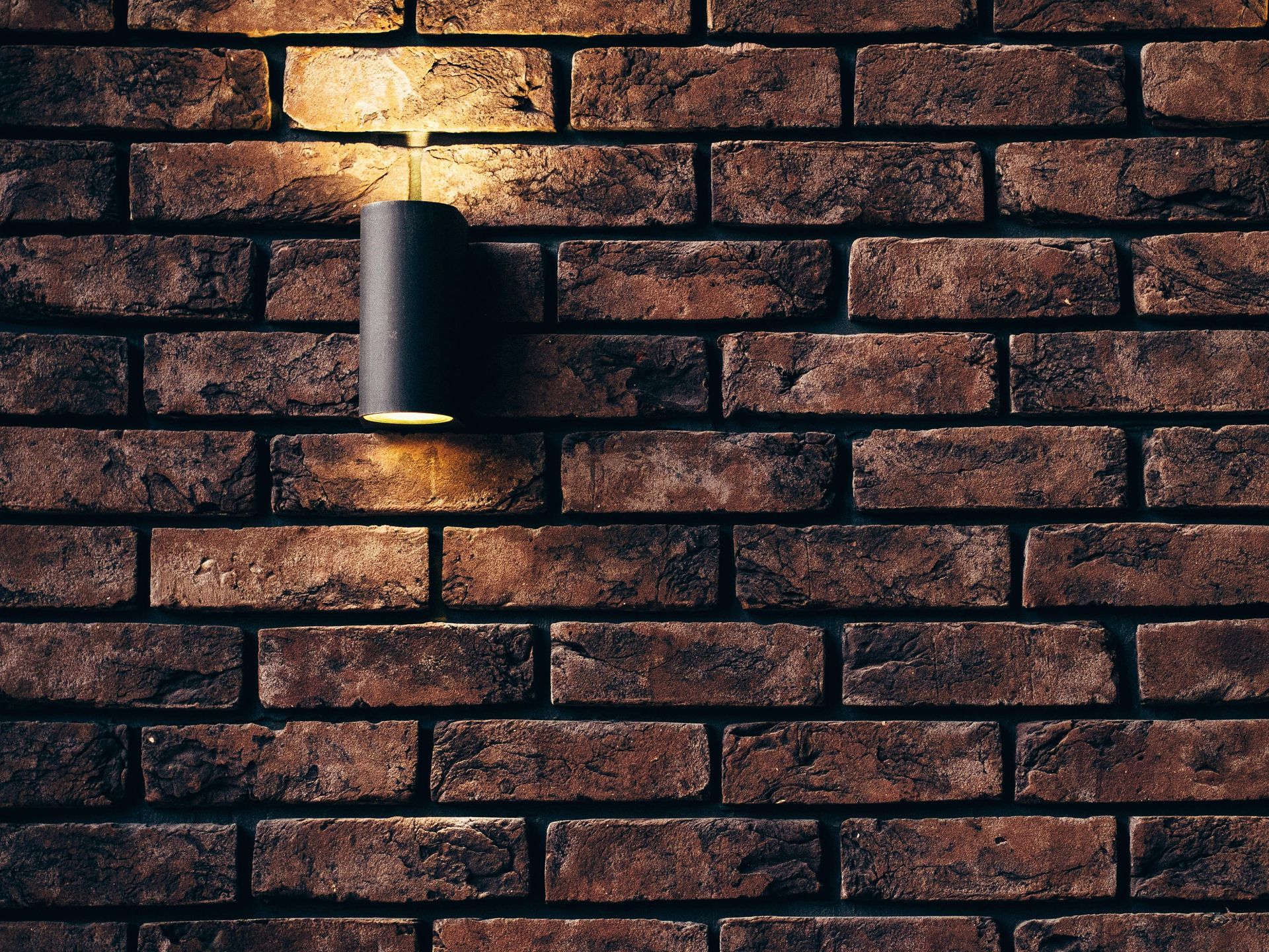 Una pared de ladrillos con una luz encendida.