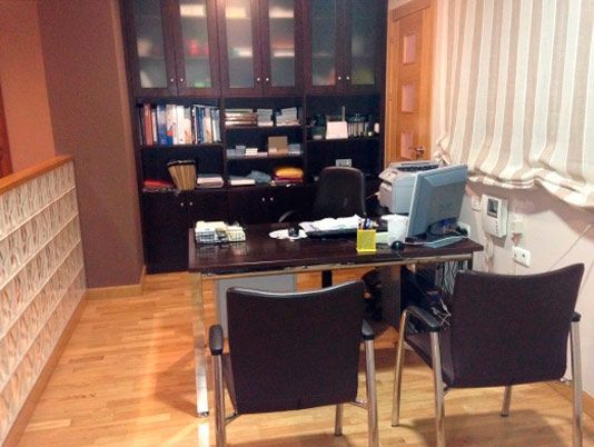 Una habitación con dos sillas y un escritorio con una computadora encima.