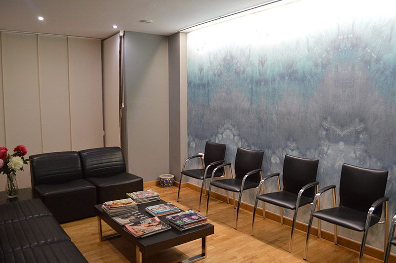 Una sala de espera con un sofá, sillas y una mesa de café.