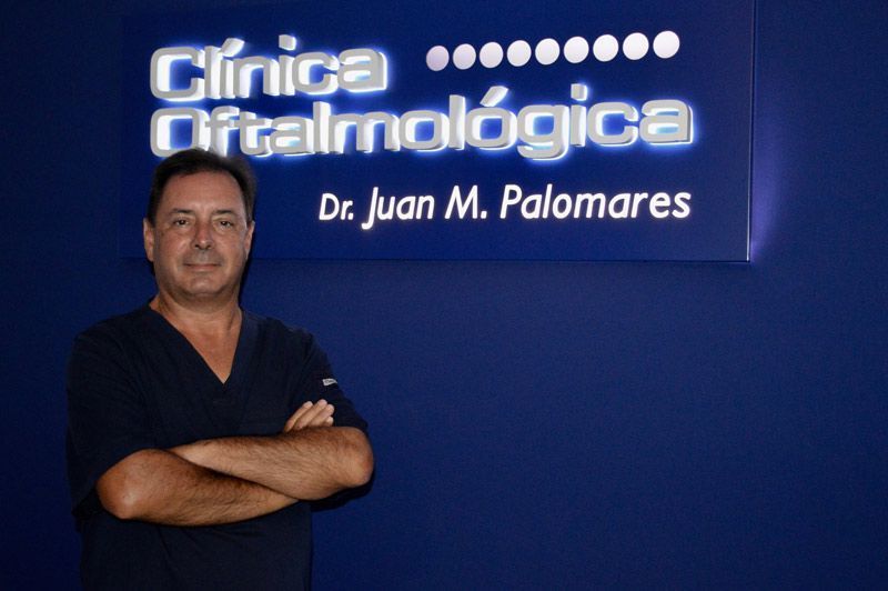 Un hombre parado frente a un cartel que dice Clínica Oftalmológica.