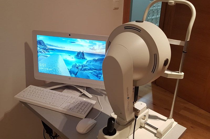 Un monitor de computadora está sobre un escritorio al lado de un teclado y un mouse.