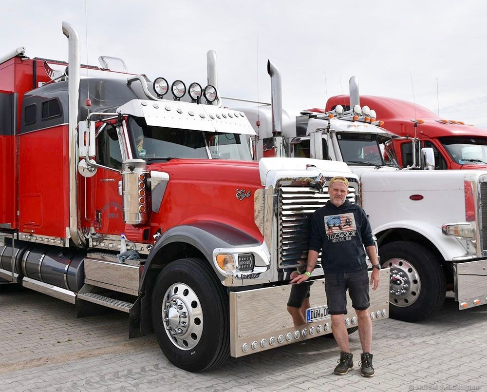 Ein Mann steht vor zwei Sattelschleppern.