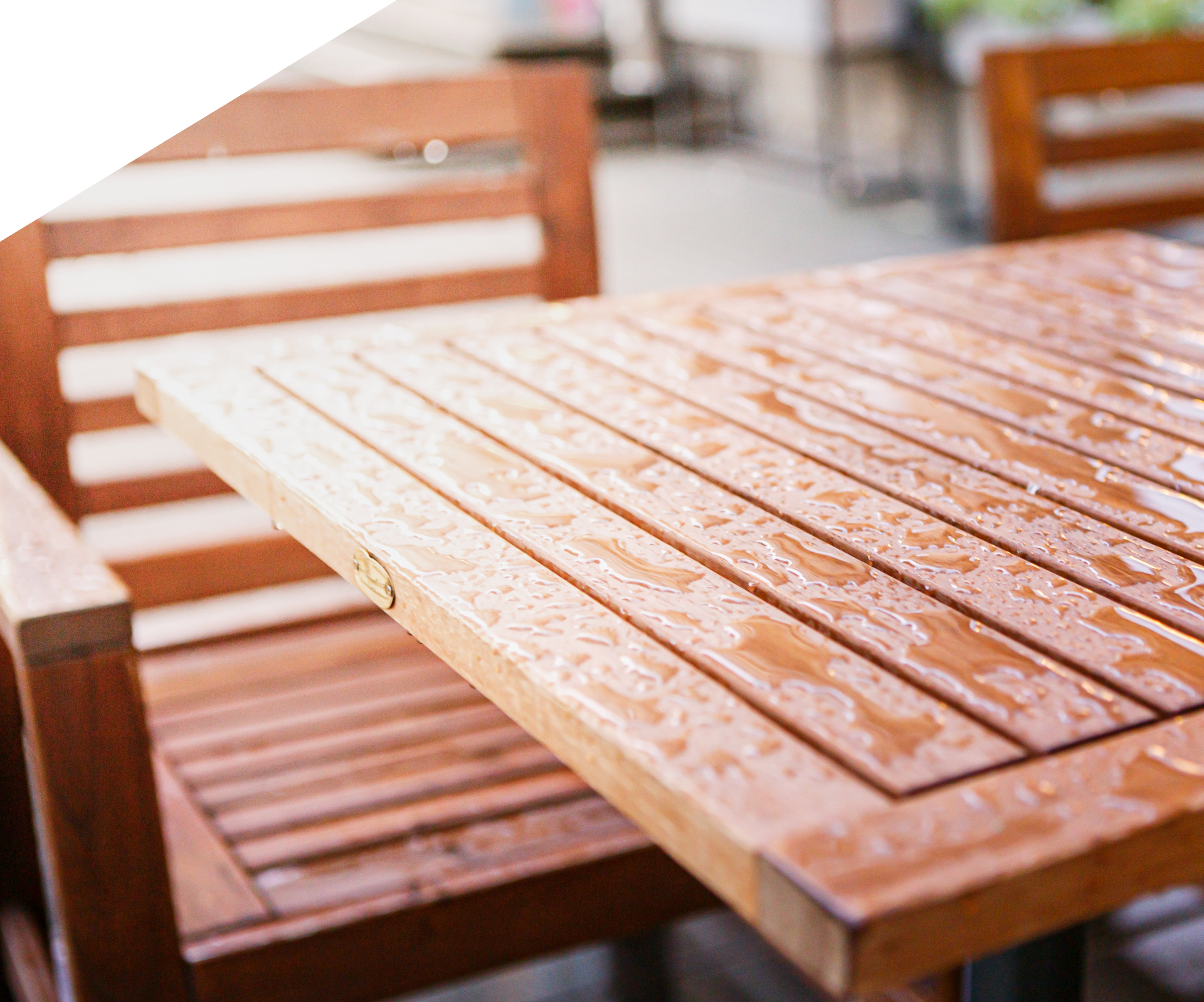 De l'eau sur une table et des chaises de terrasse en bois