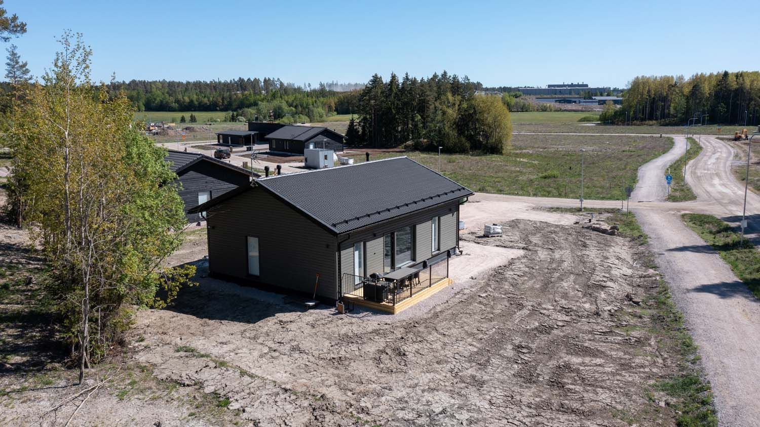 Pieni harmaa vaja hiekkatontilla mutkittelevan tien varrella maaseudulla