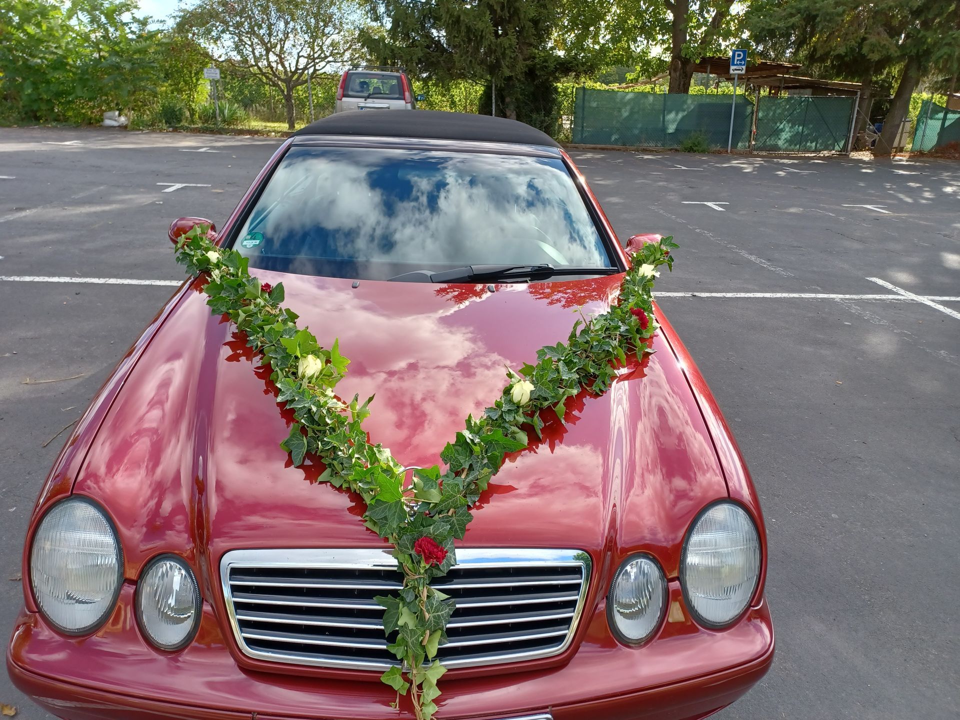 Rotes Auto mit Hochzeitsfloristik