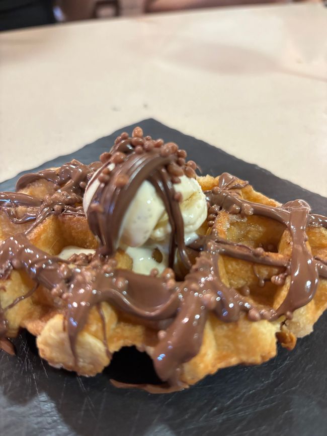 Un plato blanco cubierto con un pastel de chocolate y helado.