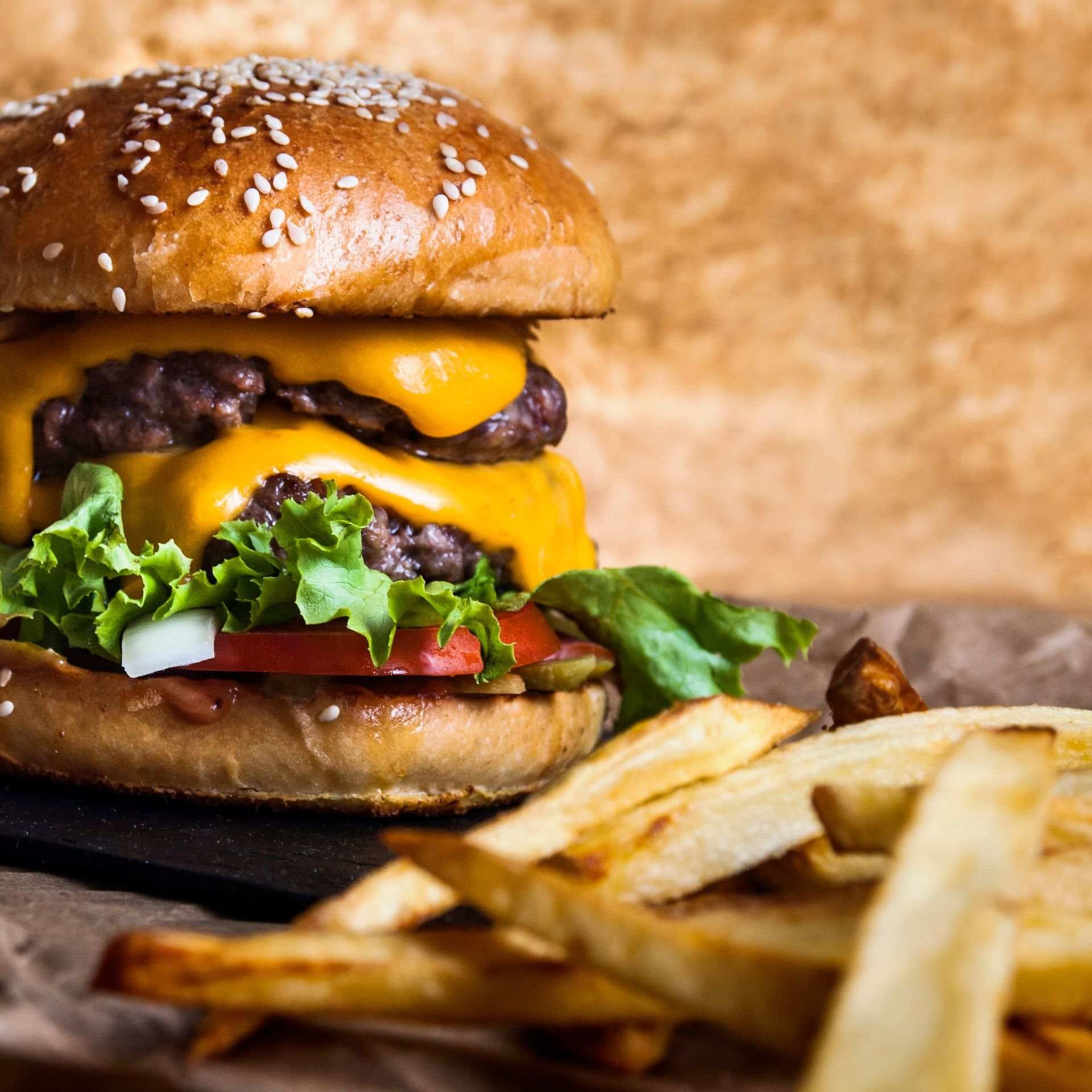 Un primer plano de una hamburguesa y papas fritas en una mesa.