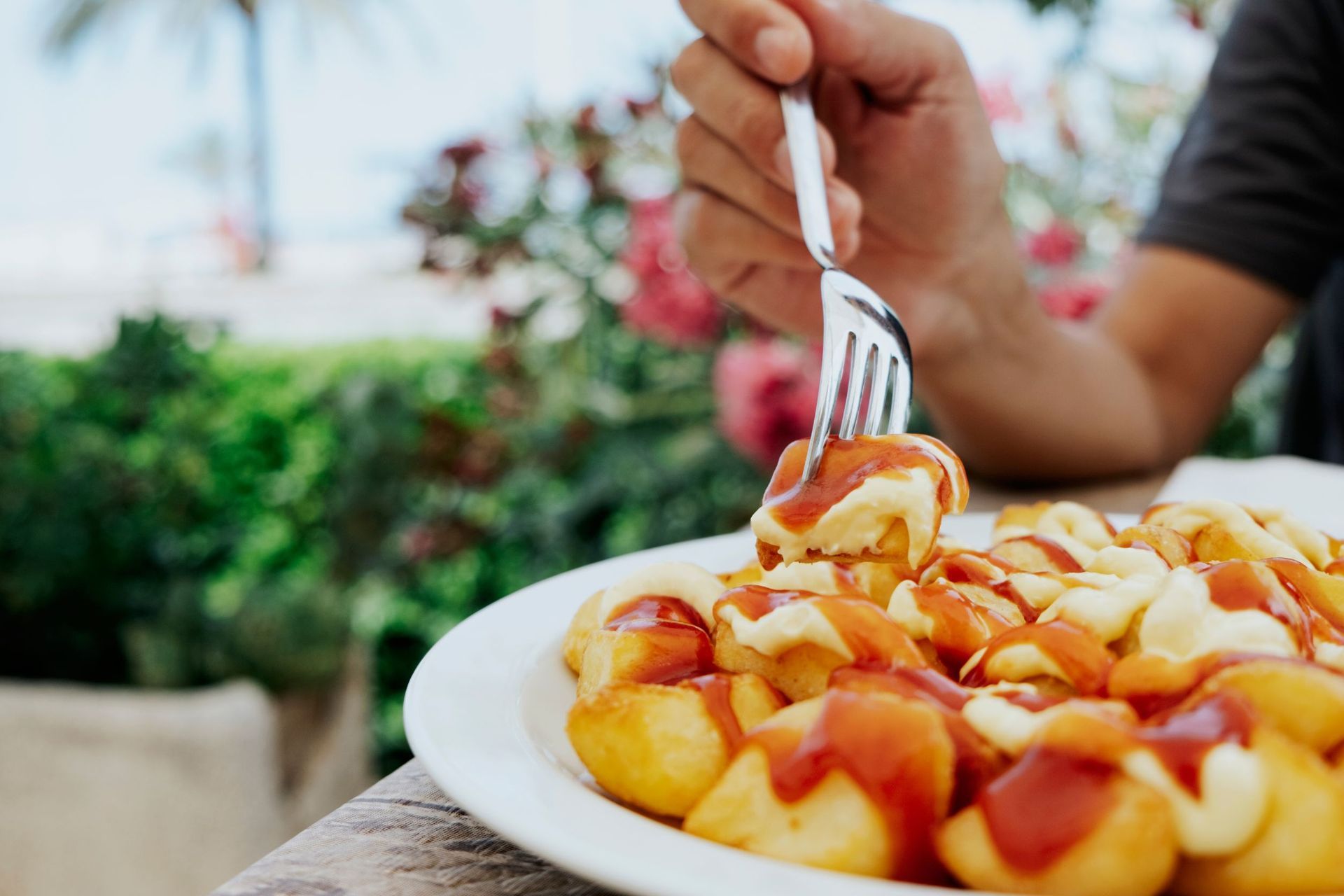 Una persona está comiendo un plato de comida con un tenedor.