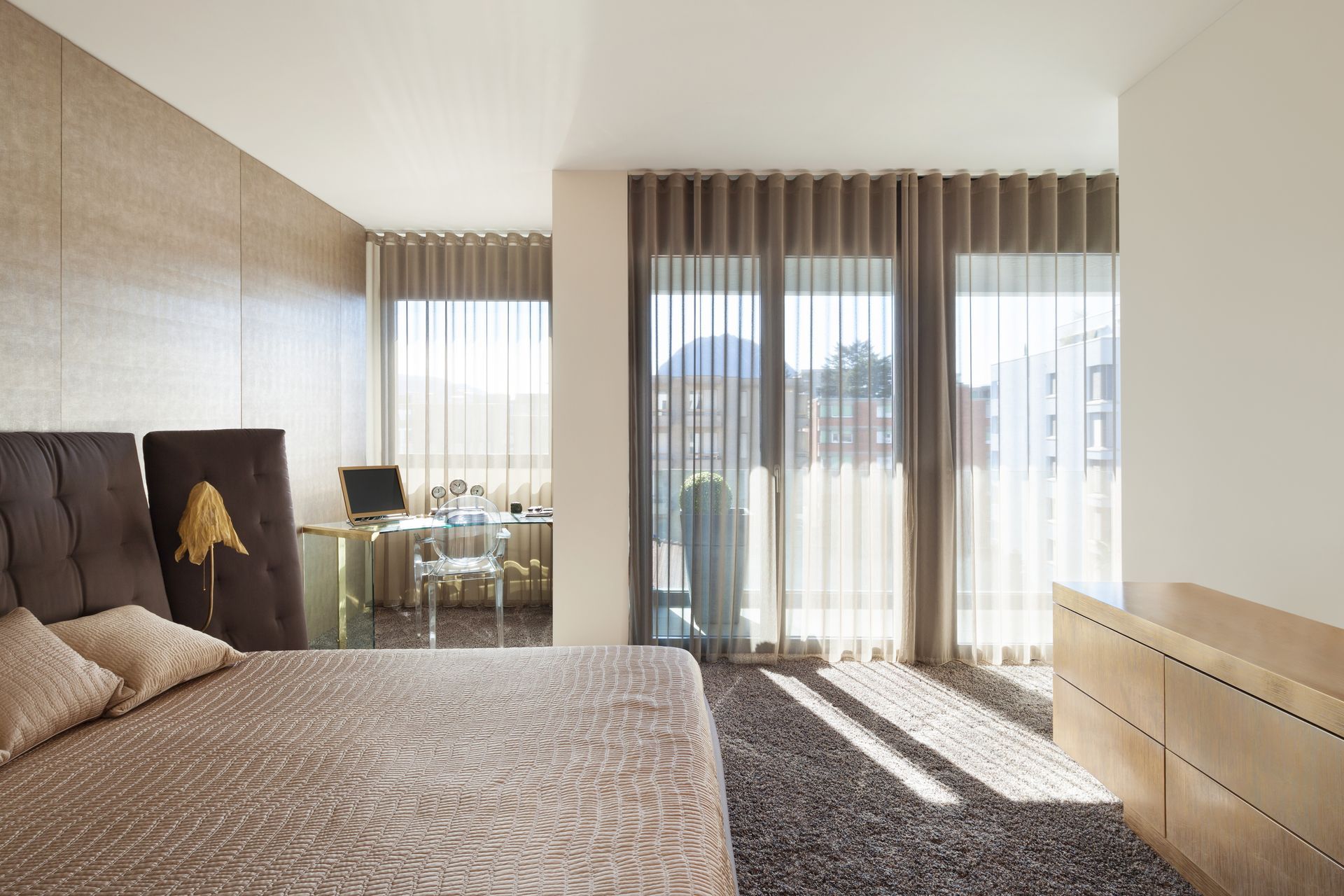 Ein Schlafzimmer mit grossem Bett und Glasschiebetüren