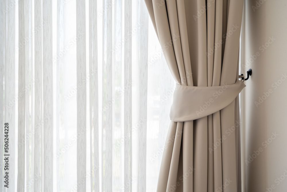 Eine Nahaufnahme eines Paars Vorhänge, die an einem Fenster hängen.