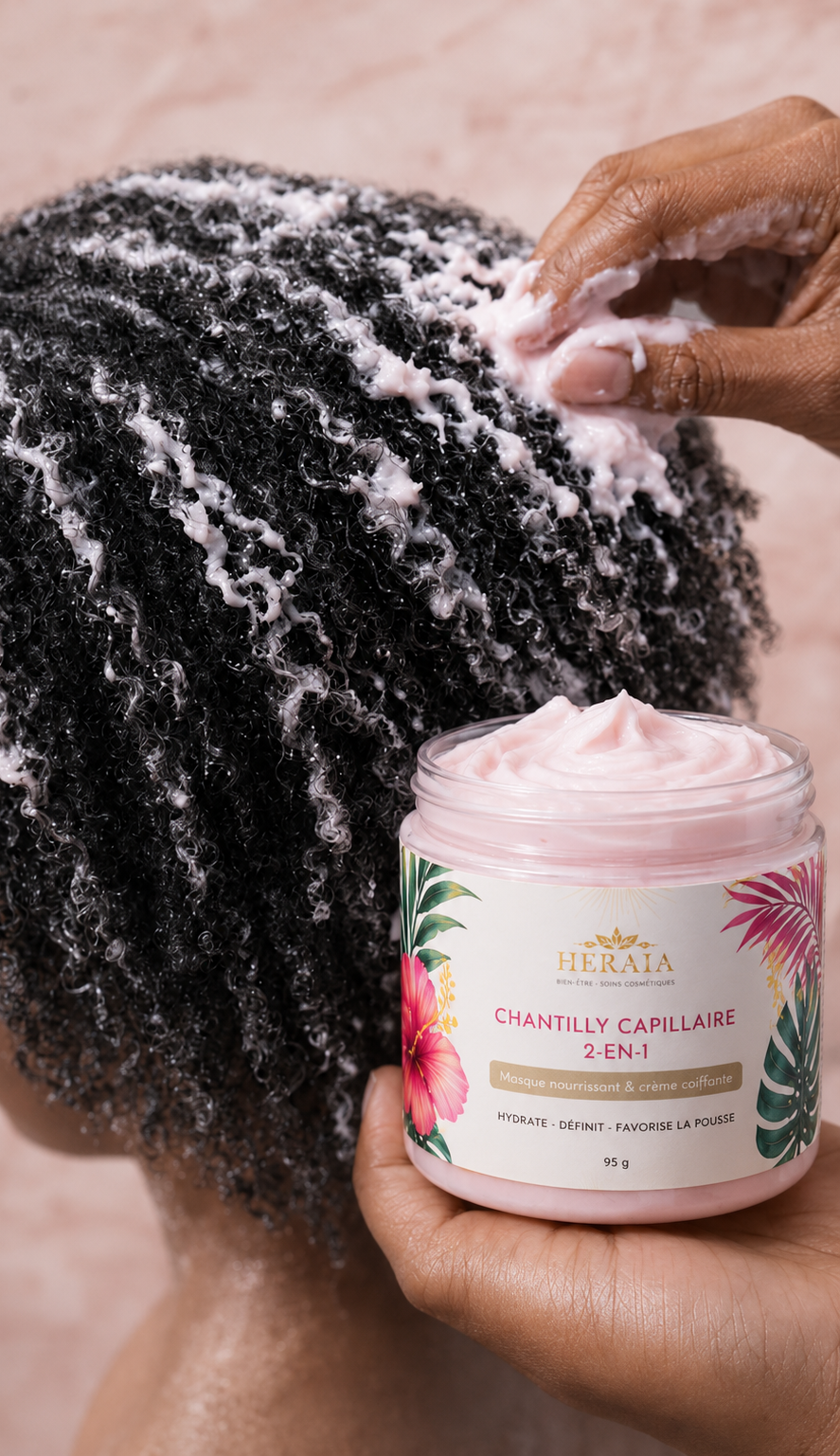 Une personne applique un produit capillaire sur des cheveux texturés avec un pot de produit Chantilly Capellin.