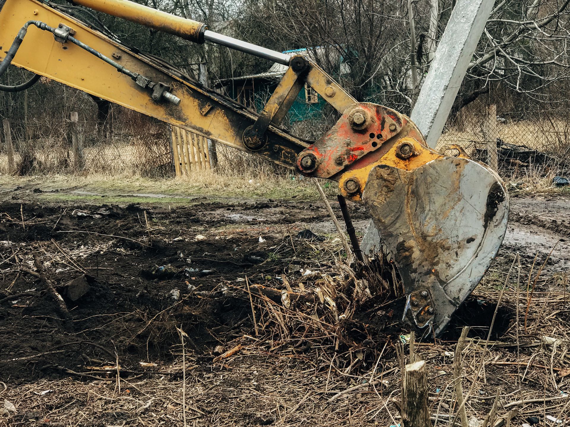 Godet jaune d'une excavatrice creusant un sol pour retirer une racine