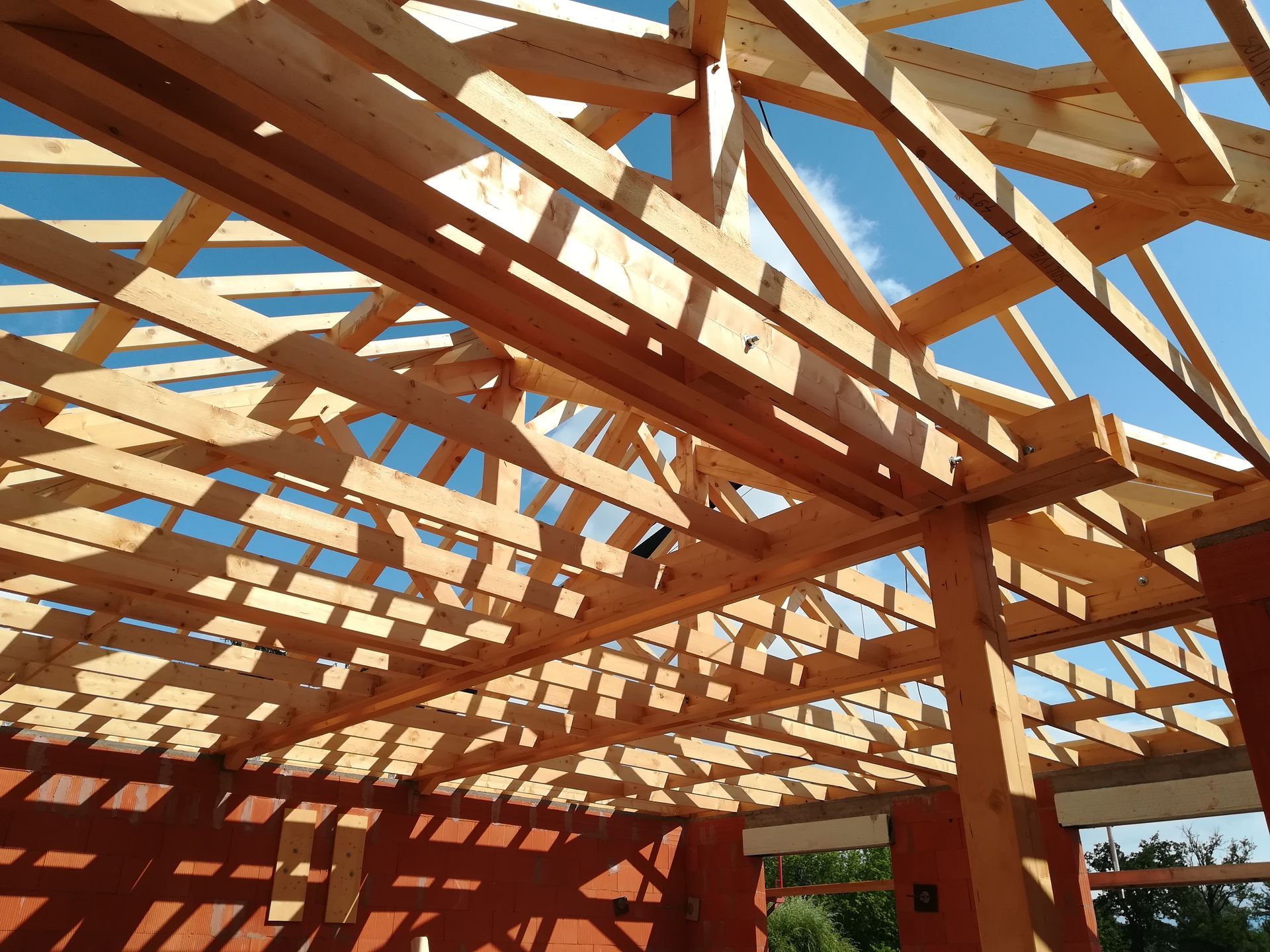 Poutres en bois formant la structure complexe du toit d'un bâtiment.