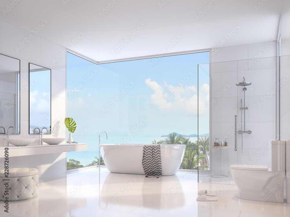 Strahlend weißes, modernes Badezimmer mit Meerblick durch ein großes Fenster, weißer Badewanne und Armaturen.