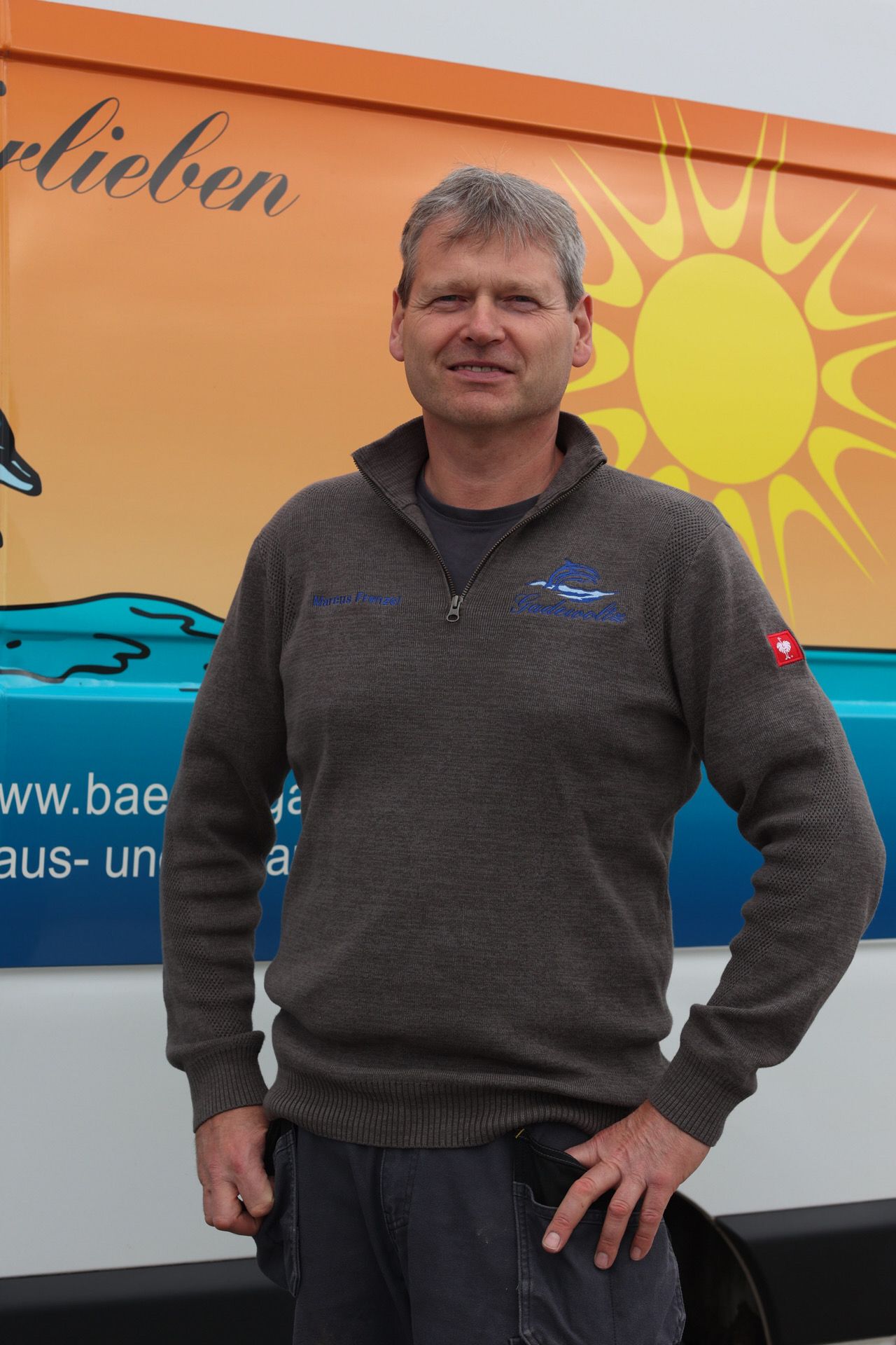 Ein Mann steht vor einem Schild mit der Aufschrift „Bäder“